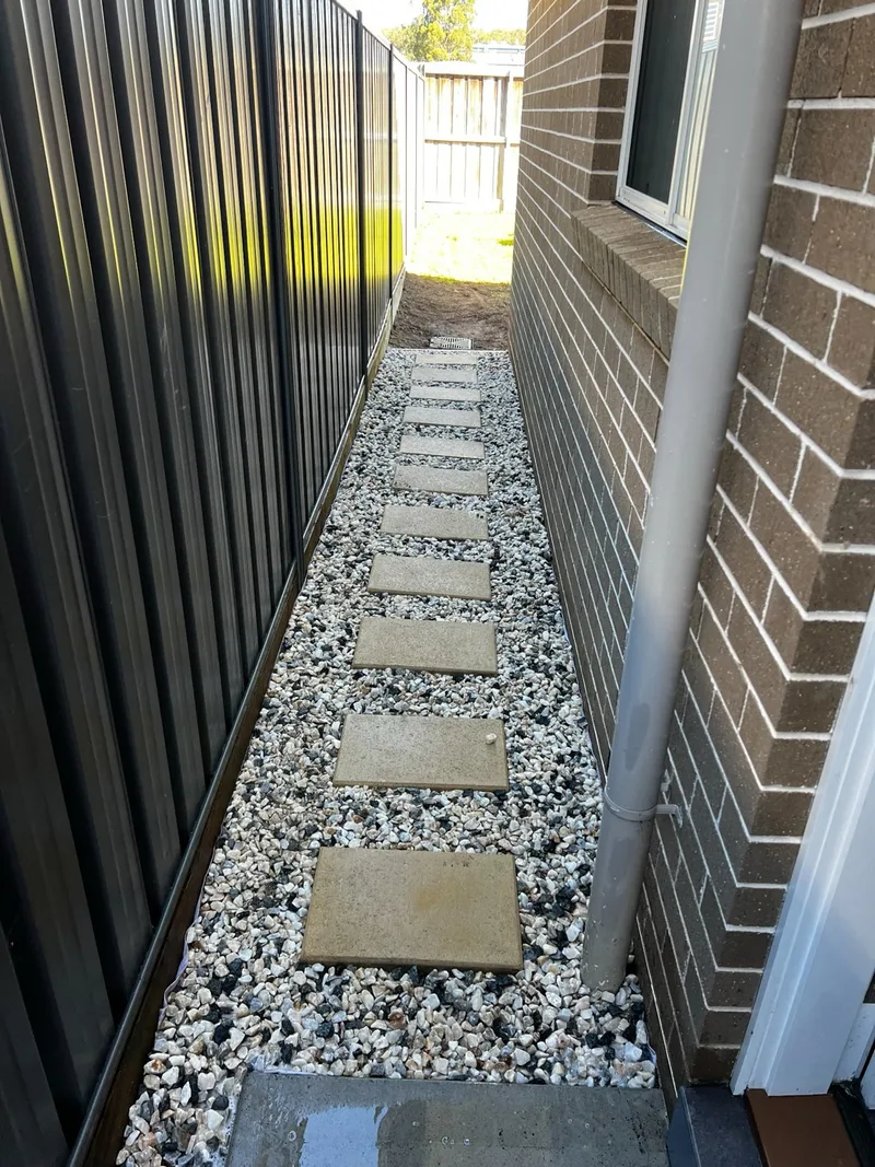 Finished stepping-stone path with decorative gravel beside a Gordon home.