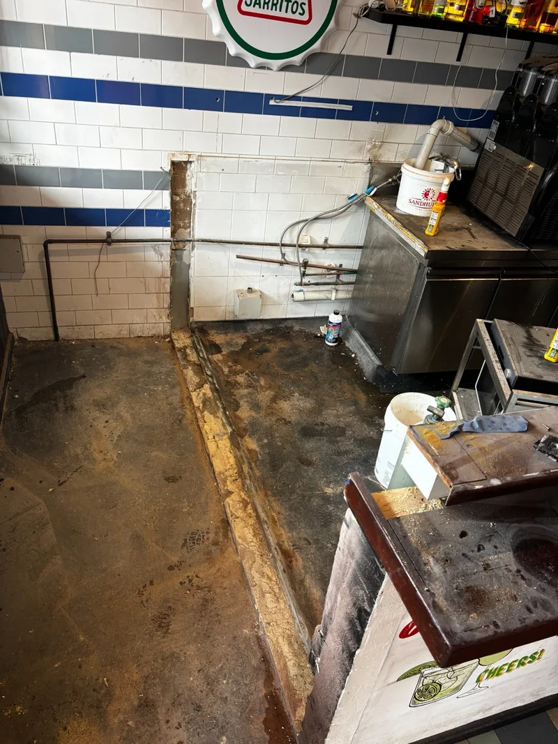 Cleared floor area after the brick wall and sink were removed.